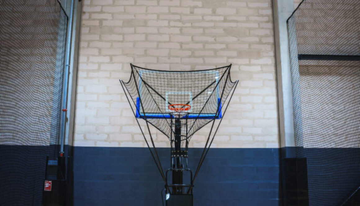 Automated basketball shooting machine in an indoor court, showcasing advanced basketball training technology for skill development and efficiency.