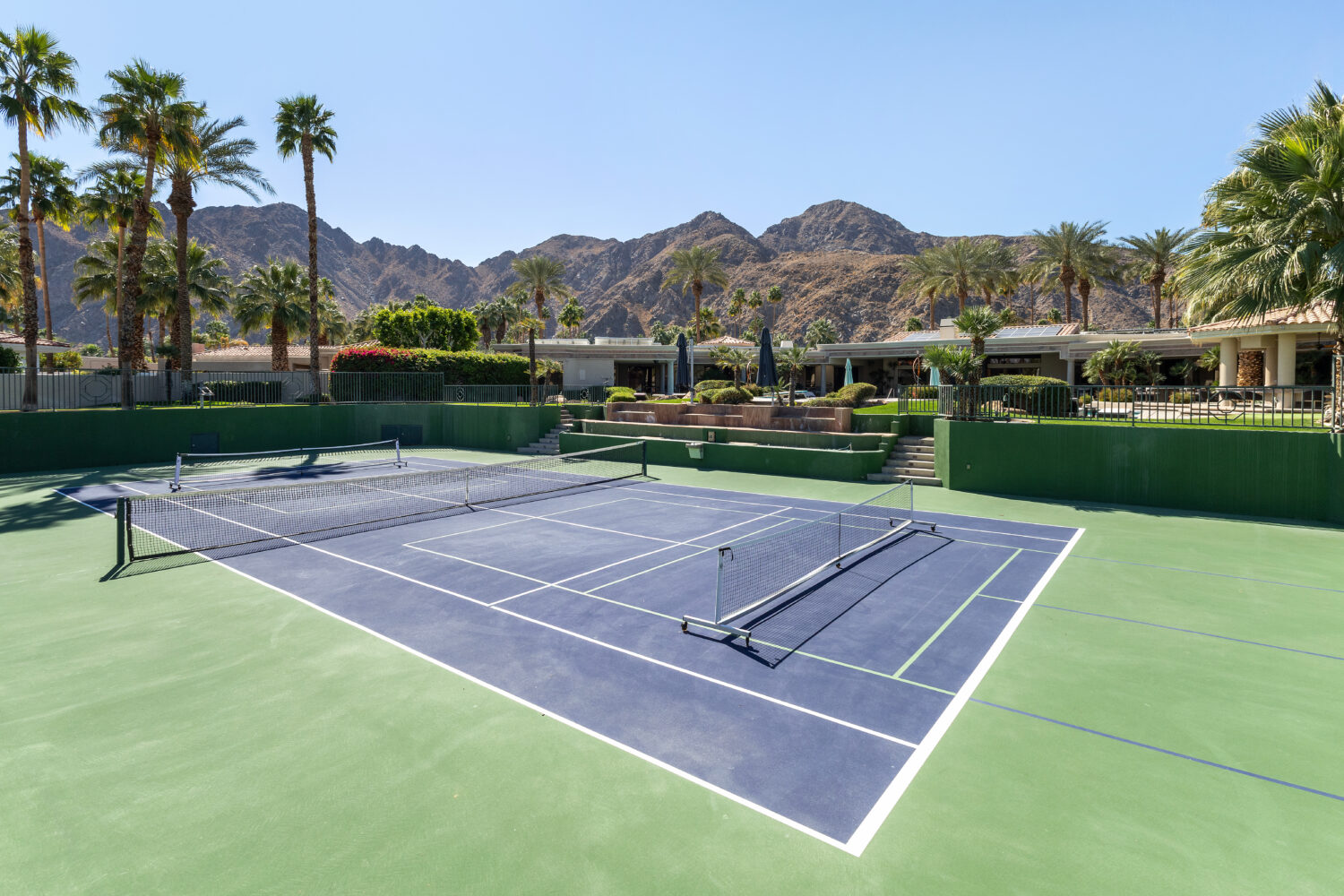 Tennis and pickleball court at large luxury estate Outdoor pickleball court at a multi-use facility, showcasing effective pickleball court management in a scenic setting