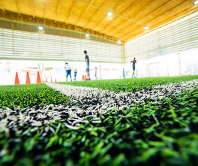 View from the field inside an indoor soccer facility, showing turf, lighting, and training space - important elements to consider when building an indoor soccer facility.