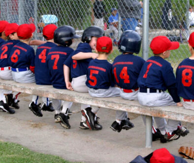 Youth baseball team on the bench during a game, highlighting the importance of baseball team management