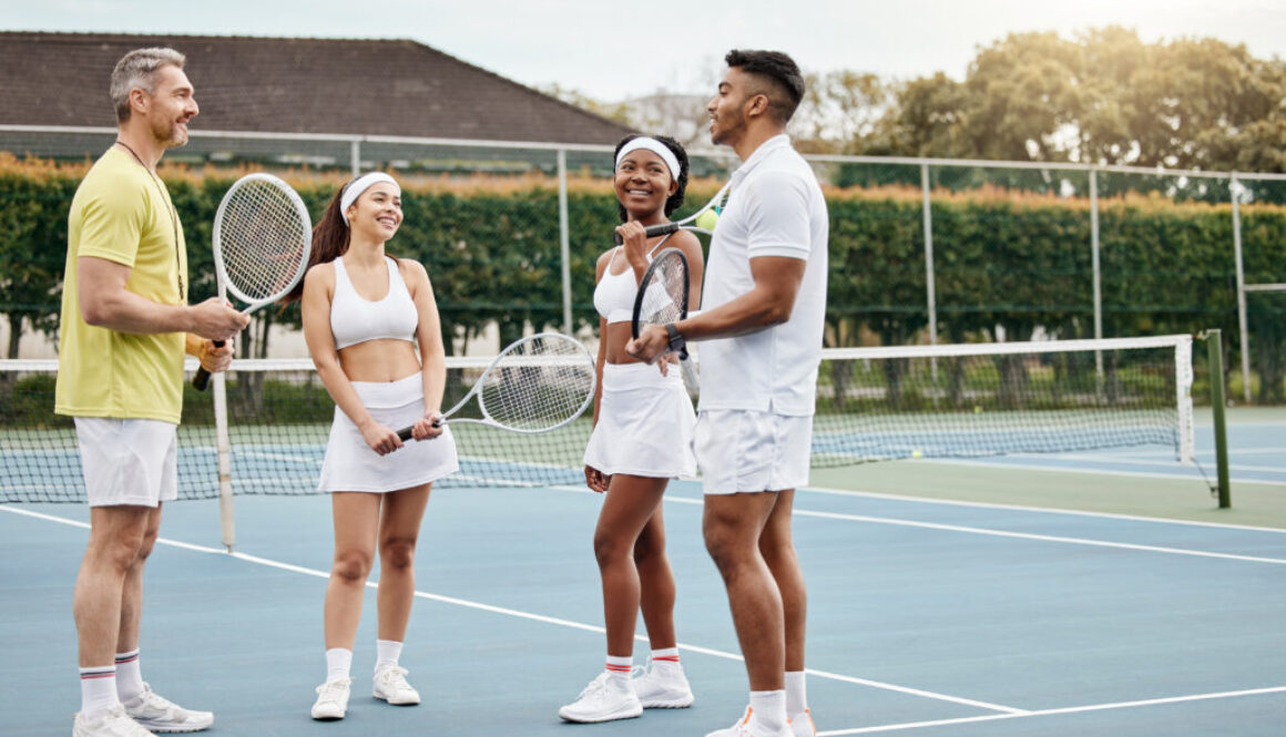 Tennis coach speaking to students on an outdoor court, highlighting how tennis club management coordinates schedules for players