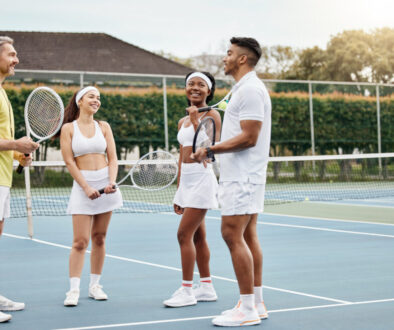 Tennis coach speaking to students on an outdoor court, highlighting how tennis club management coordinates schedules for players