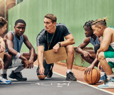 Basketball strategy, team sports and coach talking to USA sport group about coaching for game on court. Young athlete students in communication about idea during training for professional competition