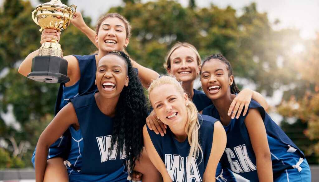 Netball game, team sports and trophy winner in sport competition on court, collaboration for winning and teamwork for success in event. Women athlete celebrate prize and champion achievement together