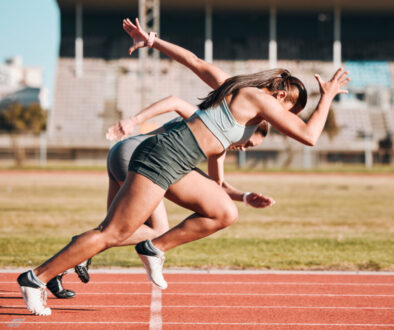 Action, sports and athlete running sprint in competition or fitness game or training for energy wellness on track. Race, stadium and athletic people or runner exercise, speed and workout performance